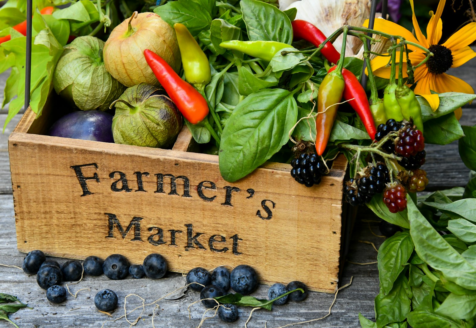 A wooden farmers market crate filled with fresh produce