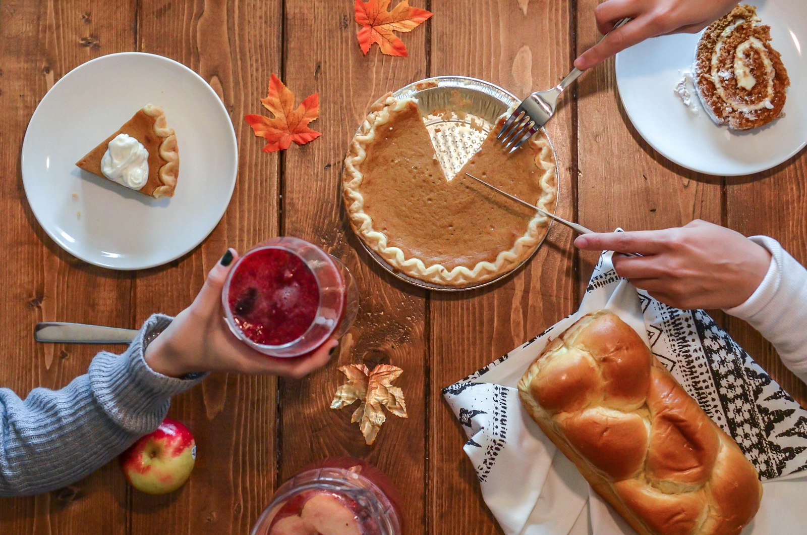 A holiday table with pies, bread and dessert