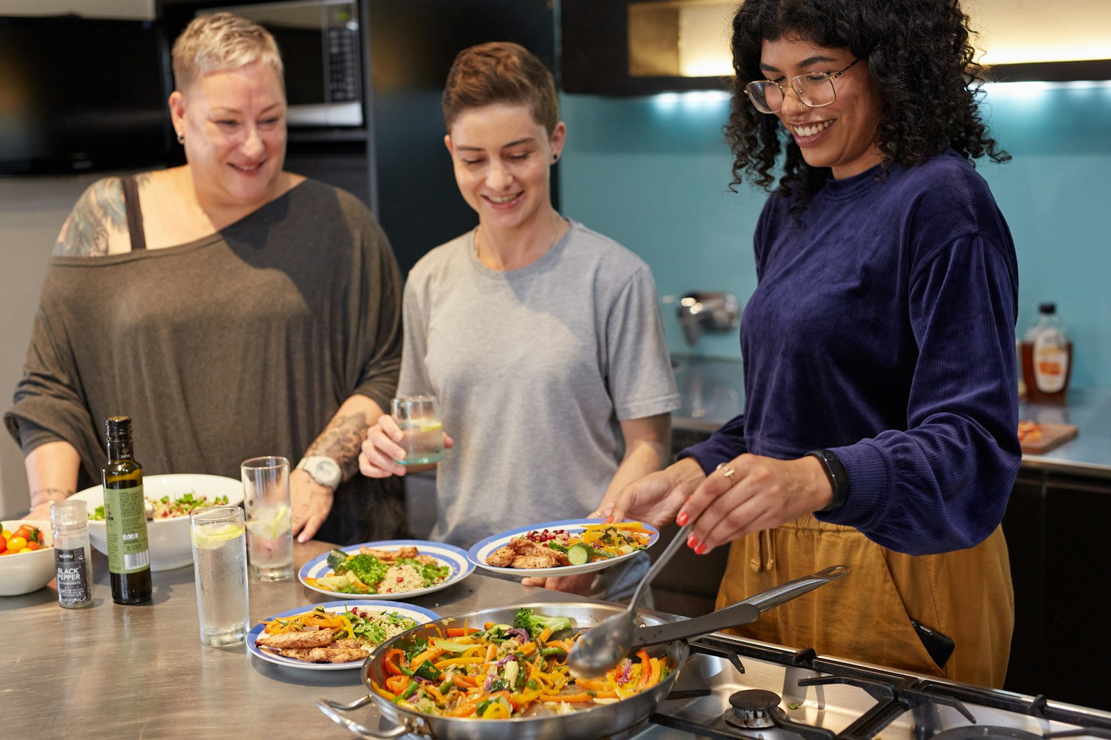 Three women cooking together in a kitchen