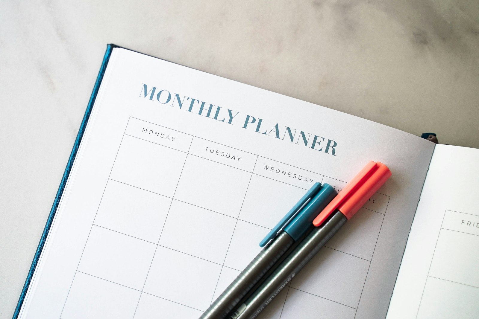 A monthly planner with two pens