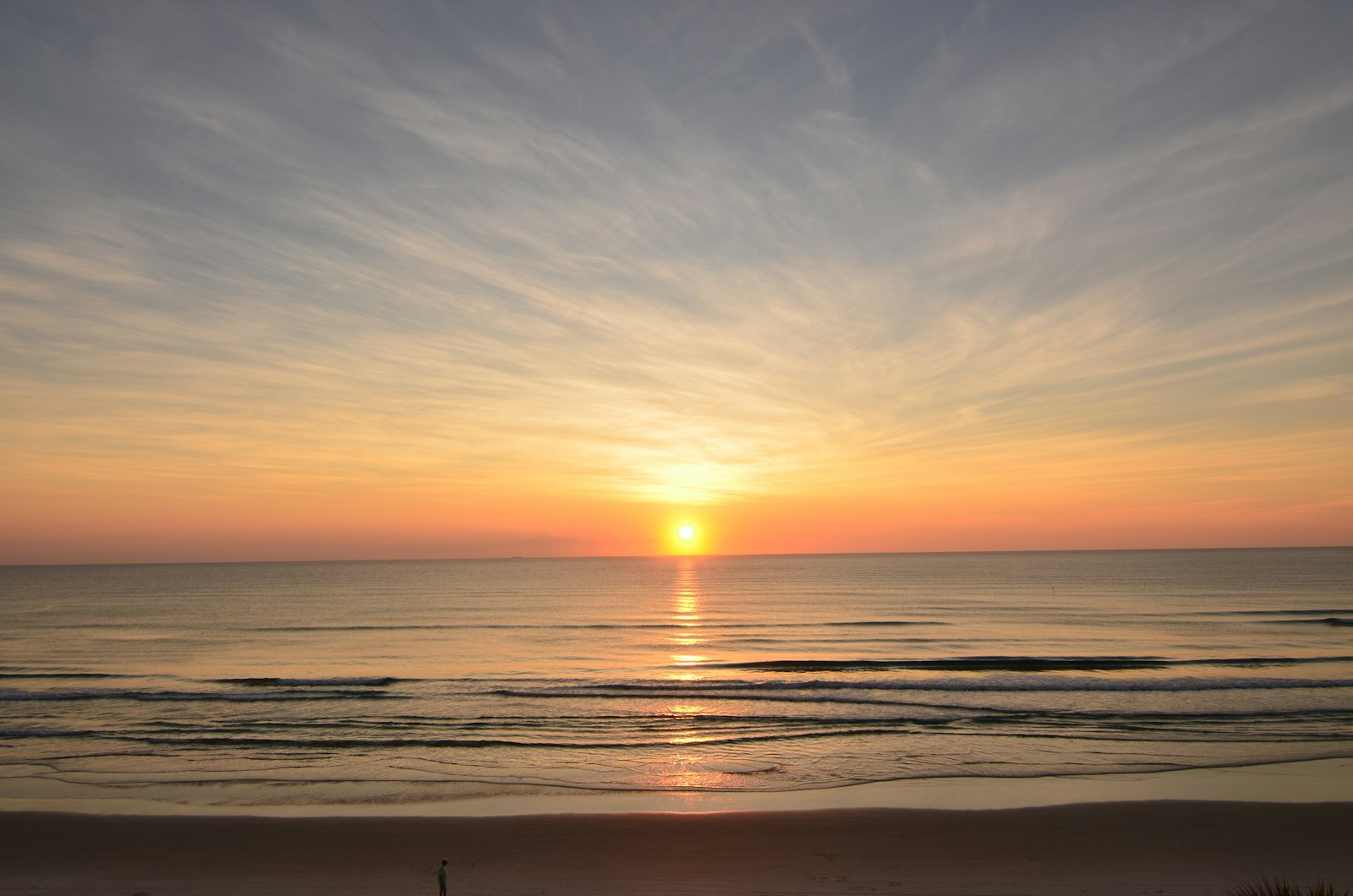 The sun rising over a calm sea