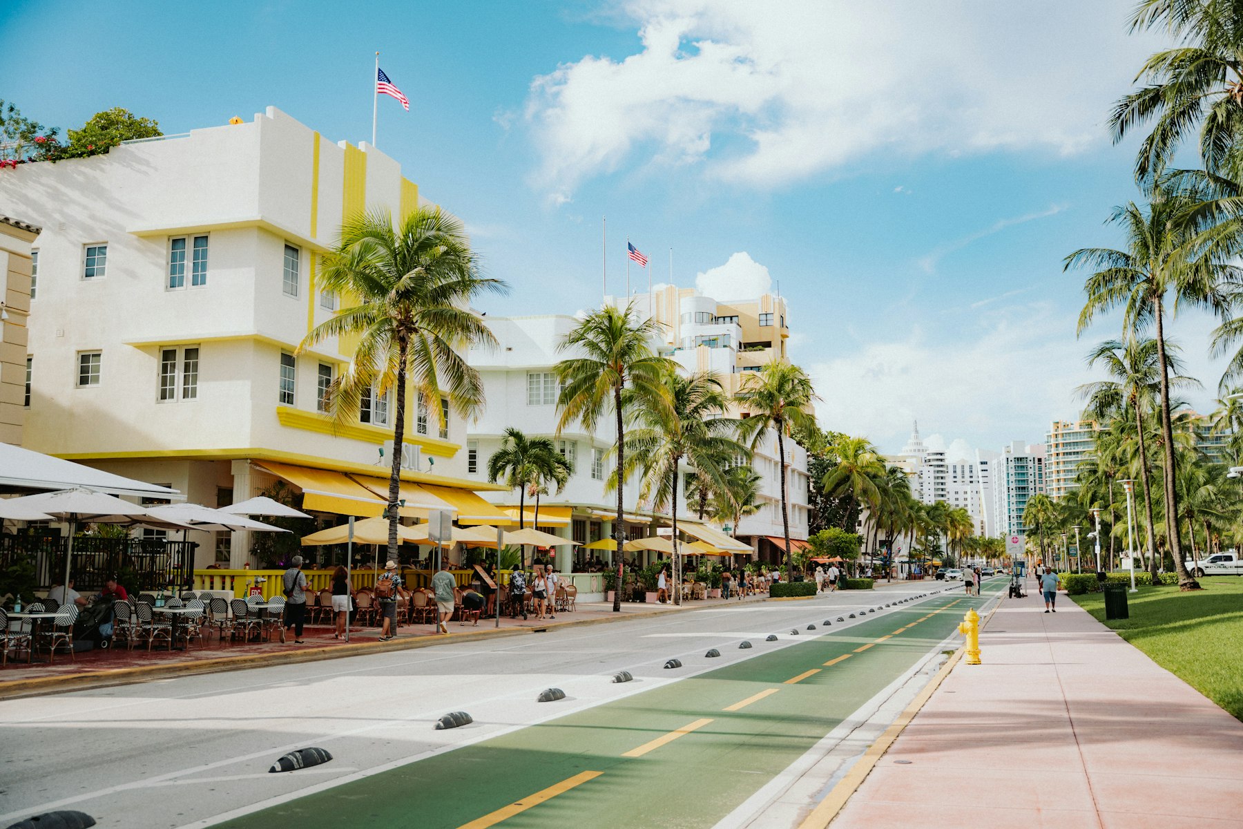 Pastel Art Deco hotels and palm trees along a Miami Beach street