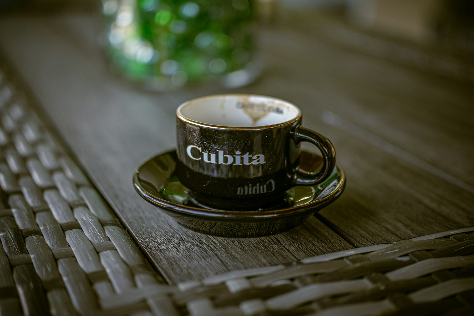 A small black Cubita espresso cup on a saucer